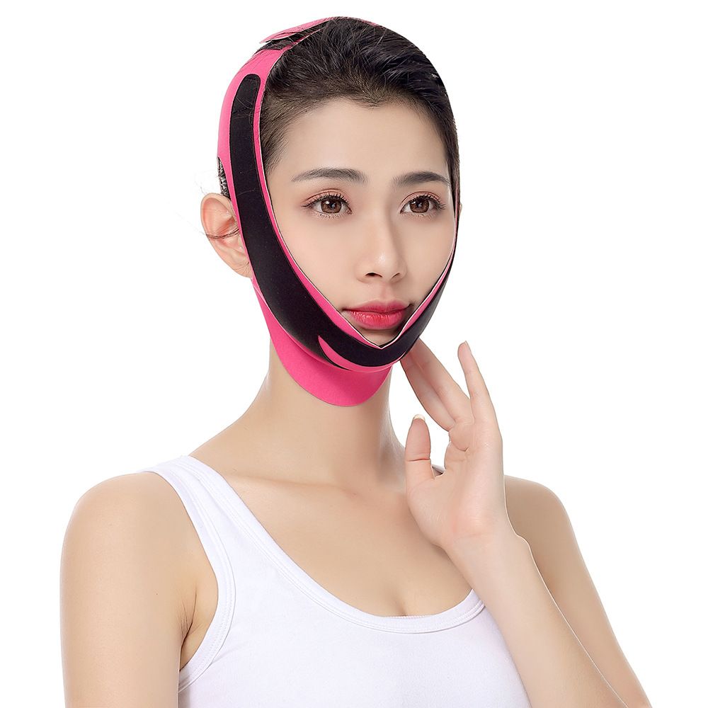 Woman wearing a pink and black face slimming device.