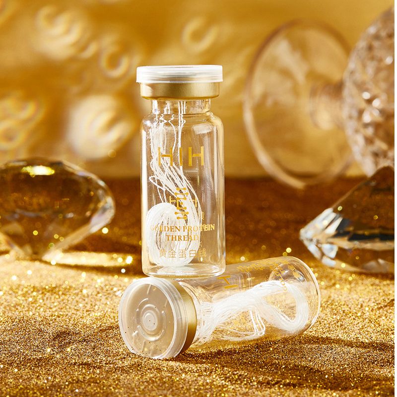 Vial with a white cap on a gold glittery background
