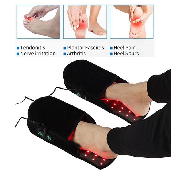 Person wearing black foot massagers with red LED lights.